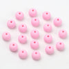 A collection of pink matte acrylic beads scattered on a white background.