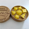 A set of yellow cheese dice cubes arranged on a round wooden platter, with a matching carrying case nearby.