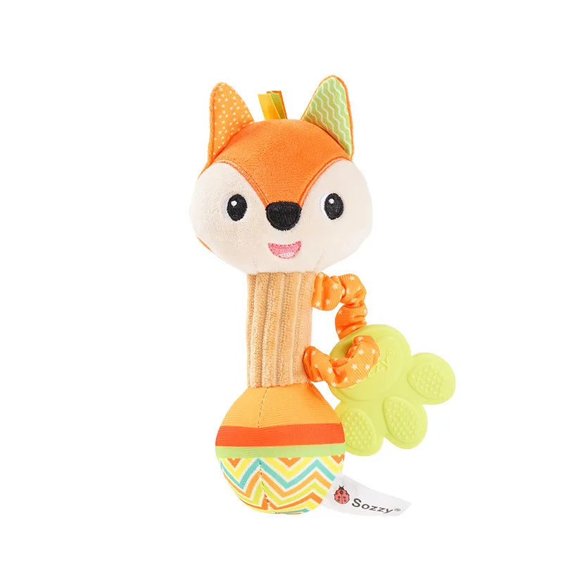 An orange fox plush toy with a yellow tongue and a green rattle attached.