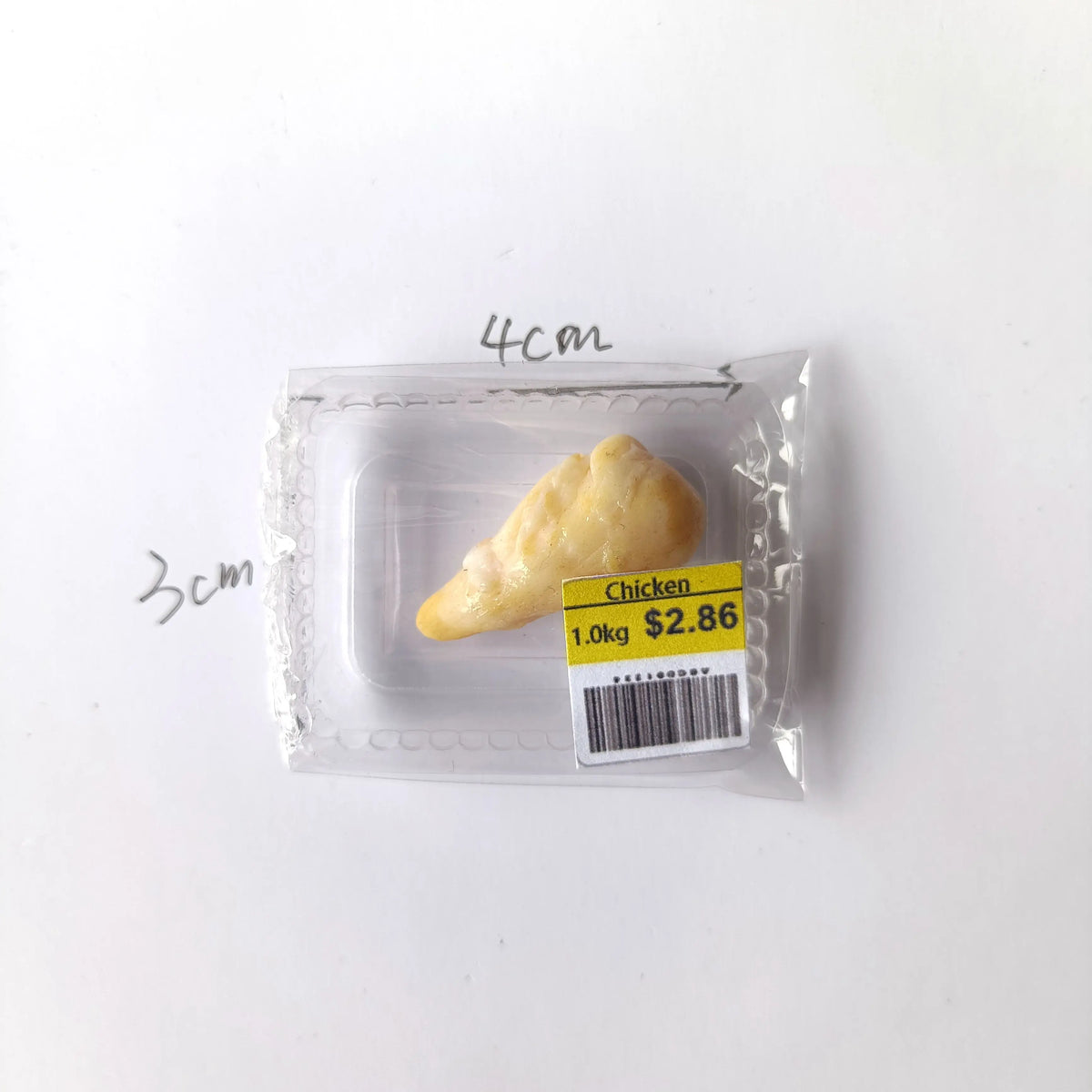 A small package containing a piece of cooked chicken, labeled as 1.0kg for $2.86.