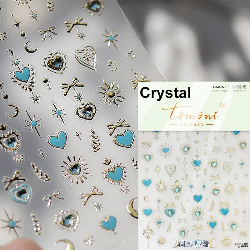 Silver and gold crystal nail art stickers featuring hearts, stars, moons, and crosses