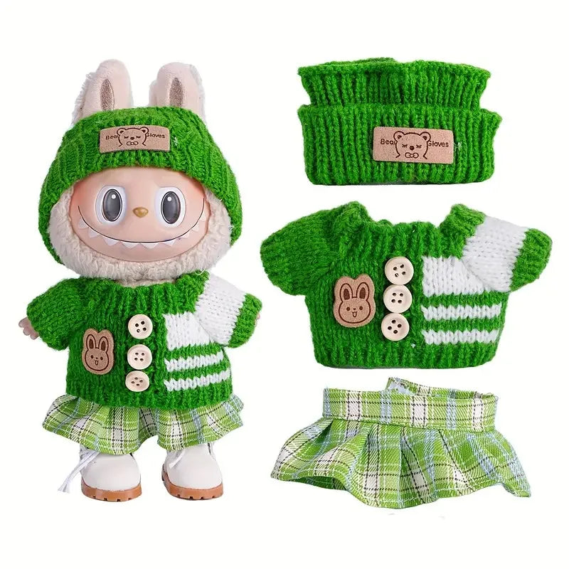 A set of knitted clothing and accessories for a doll figure including a sweater, hat, and plaid shorts.