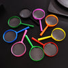 A collection of colorful magnifying glasses with various colored handles and circular lenses on a dark surface.