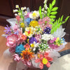A colorful bouquet of everlasting flowers made from building blocks featuring pink, yellow, purple, and green hues.
