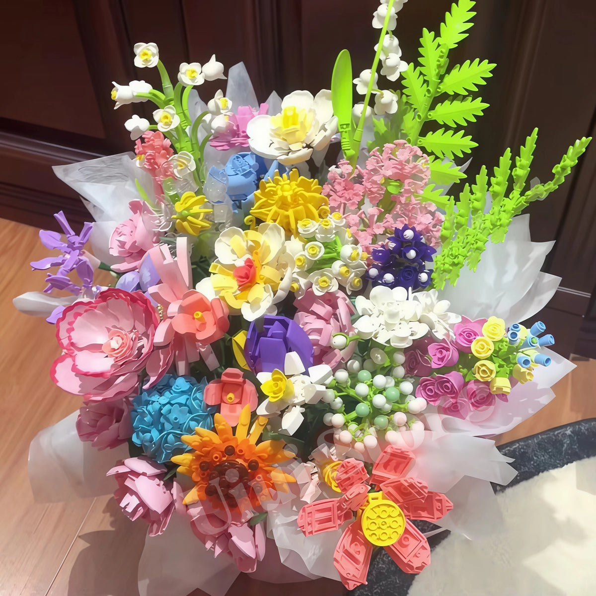 A colorful bouquet of everlasting flowers made from building blocks featuring pink, yellow, purple, and green hues.