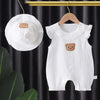 White cotton muslin baby romper and hat set with a teddy bear applique hanging on a wooden hanger