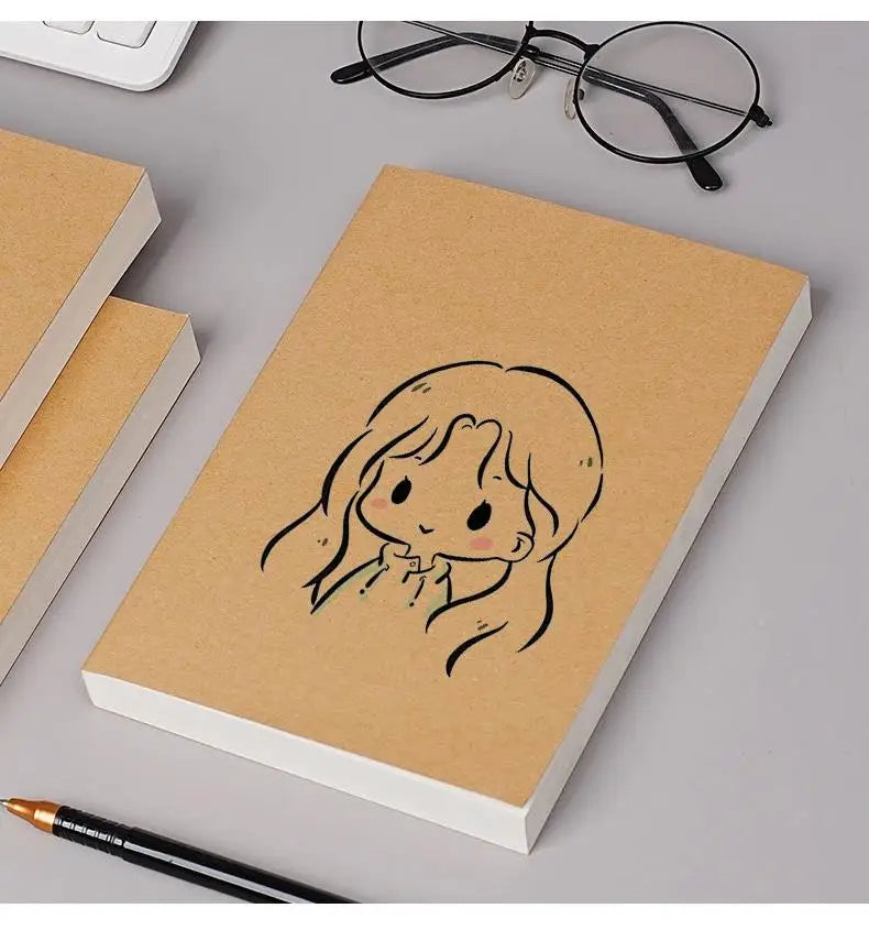 A blank kraft paper notebook with a simple line drawing of a girl's face on the cover, next to reading glasses and a pen.