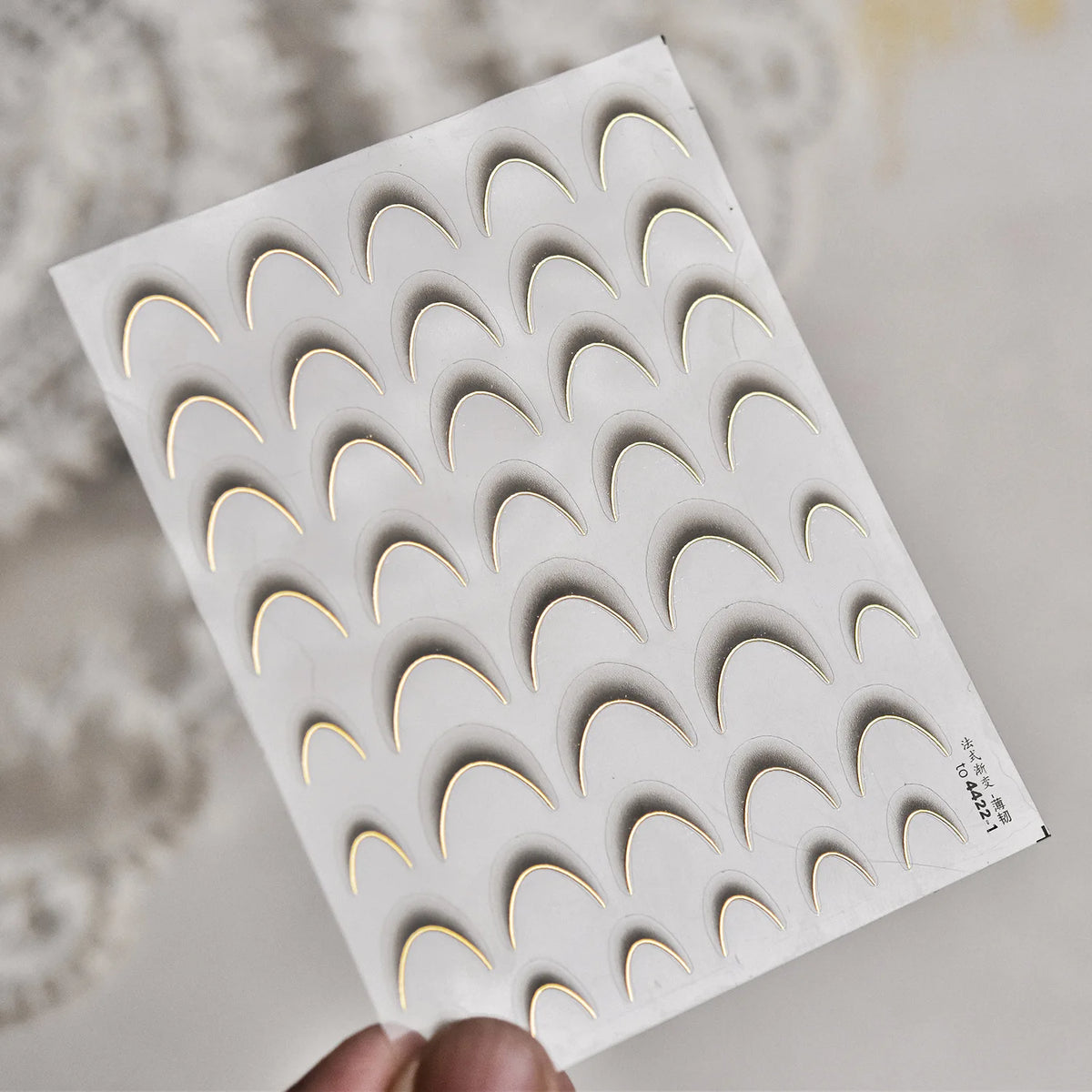 A sheet of 5D Bronzing Gothic Nail Art stickers with a repeating pattern of curved shapes.