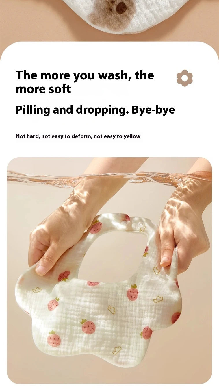 A hand is holding a white baby bandana bib with small pink strawberry embroidery.