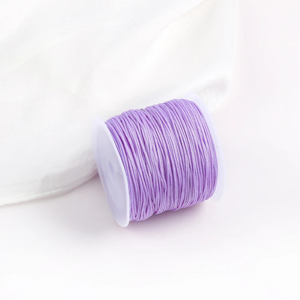 A roll of purple 0.8mm cotton nylon macrame cord for jewelry making and crafts.