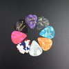 A variety pack of guitar picks in various colors and thicknesses arranged in a circle.