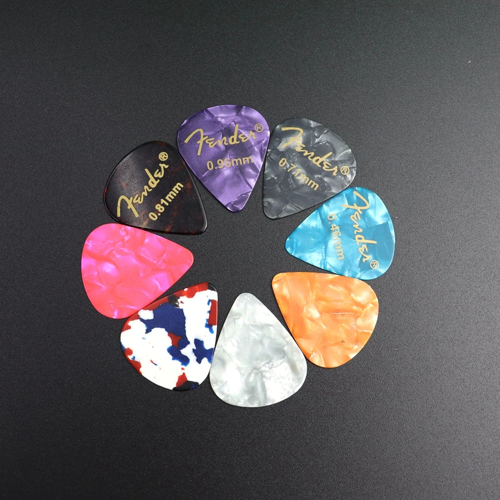 A variety pack of guitar picks in various colors and thicknesses arranged in a circle.