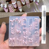 A clear silicone mold tray filled with pink bowknot nail designs and a carving pen.