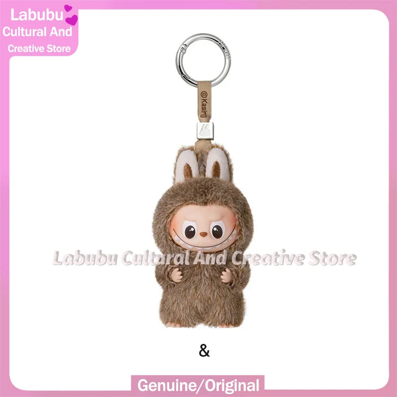 A small, fluffy brown Labubu plush doll attached to a silver keychain ring.