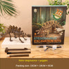 A box of a dinosaur skeleton excavation kit with tools and goggles displayed on a wooden surface.