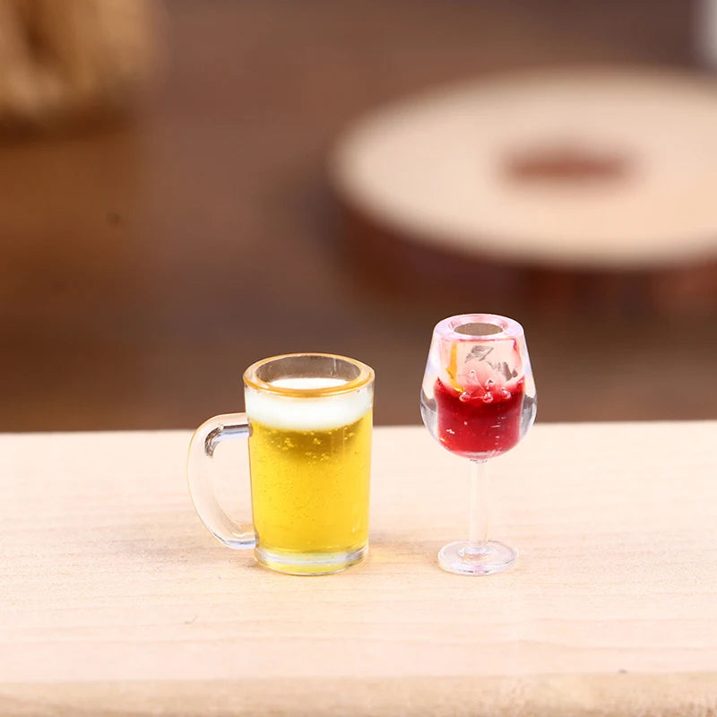 A glass of golden beer and a miniature resin wine bottle in a stemmed glass on a wooden surface.