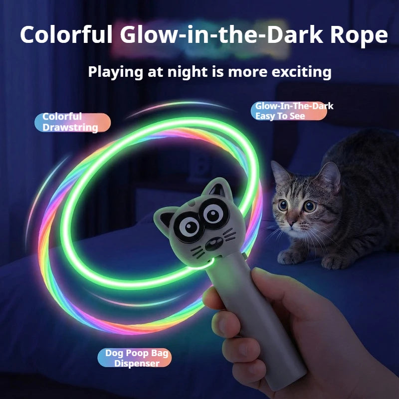 A hand holds a glow-in-the-dark rope toy that lights up in colorful rings, with a cat visible in the background.