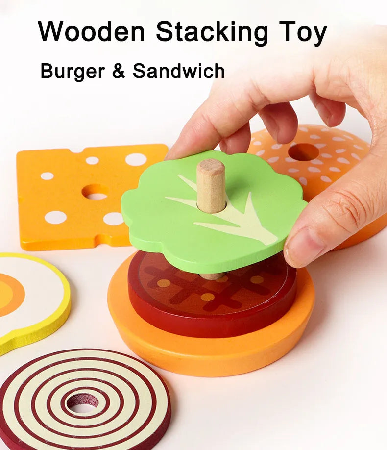 A hand is stacking wooden toy food pieces, including a green burger and sandwich piece, onto an orange base.