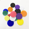 A collection of colorful plastic game markers in various shades including black, purple, orange, green, and blue.