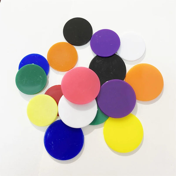 Un ensemble de marqueurs de jeu en plastique colorés, incluant des nuances de noir, violet, orange, vert et bleu.