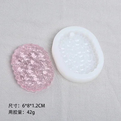 A pink silicone resin mold set featuring heart, round, oval, and rectangle shapes displayed next to a white mold container.