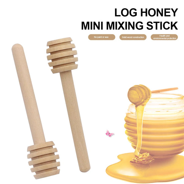 A set of mini wooden honey dipper sticks and a jar of golden honey on a yellow surface.