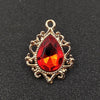 Gold plated water droplet charm featuring a red crystal rhinestone set in an ornate flower design.