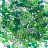 A pile of faceted green and purple bicone glass beads for jewelry making.