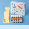 A box of a wooden word spelling game with letter tiles and cards is shown next to the game components.
