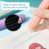 A hand applies a pink rotating double-sided adhesive dot tape glue roller onto a piece of graph paper.