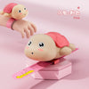 Pink turtle-shaped water gun with a pink hand and wristband shown in a studio setting.