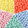 A close-up view of various colors of soft silicone beads in different sizes, including yellow, orange, pink, and blue.
