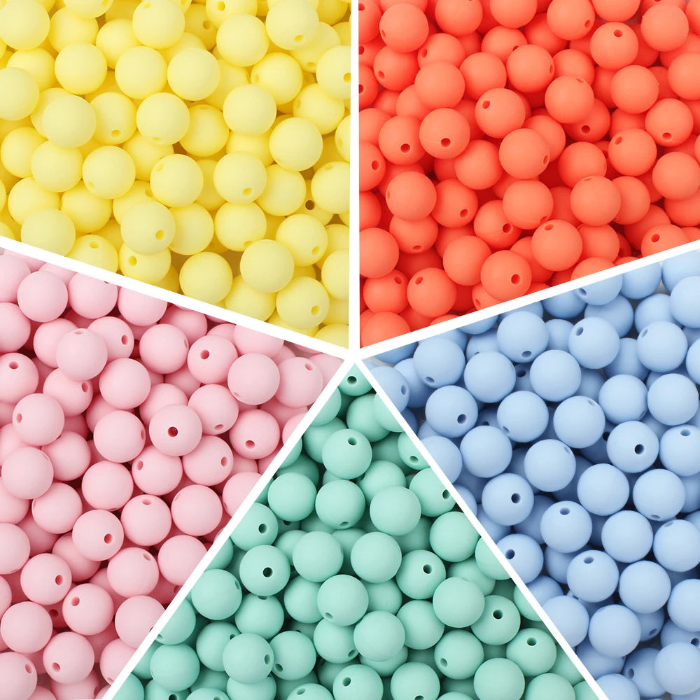 A close-up view of various colors of soft silicone beads in different sizes, including yellow, orange, pink, and blue.