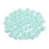 A pile of small, colorful transparent acrylic flower beads in various shades of light blue and teal.