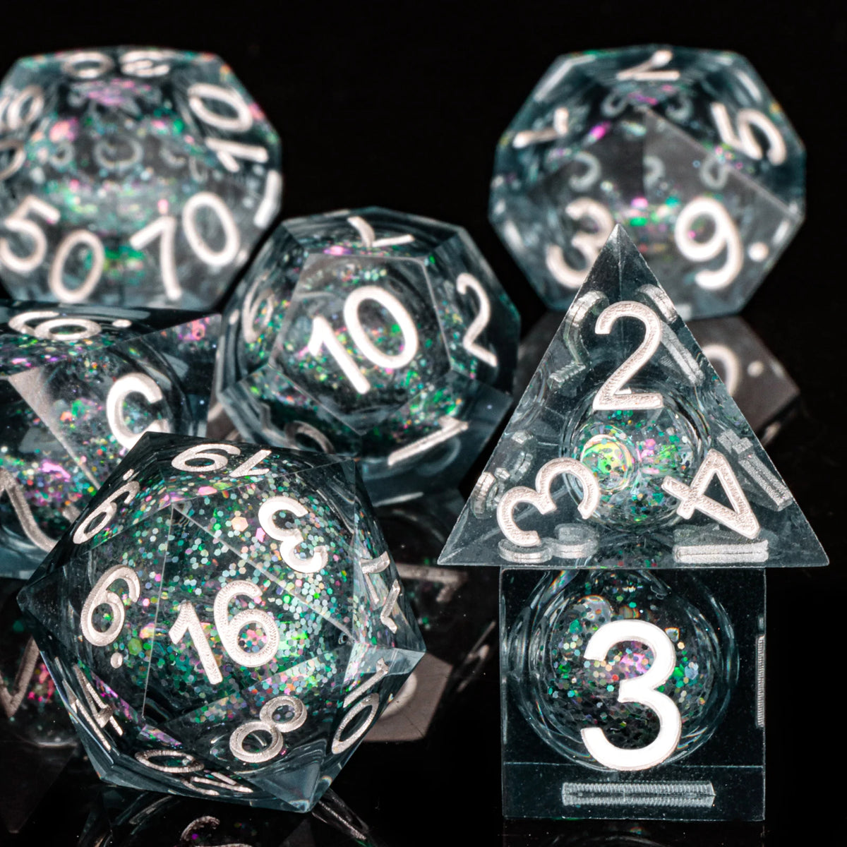 A collection of clear polyhedral dice with a galaxy finish are displayed on a dark surface.