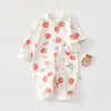 White cotton long sleeve baby romper featuring a pattern of red and green fruit leaves