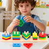 A young boy holds a green shape matching block set with various colored wooden blocks on a light wood surface.