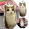 A plush keychain of a tabby cat with large eyes, featuring brown and white fur.