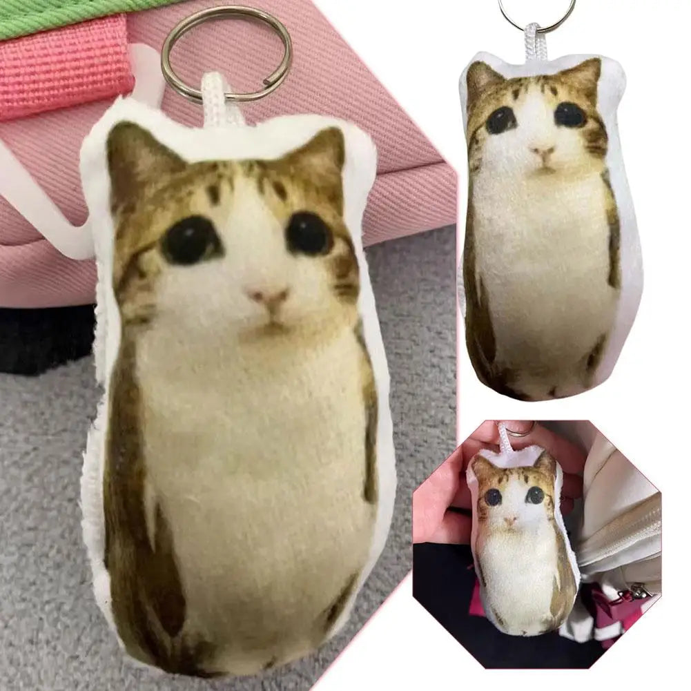 A plush keychain of a tabby cat with large eyes, featuring brown and white fur.