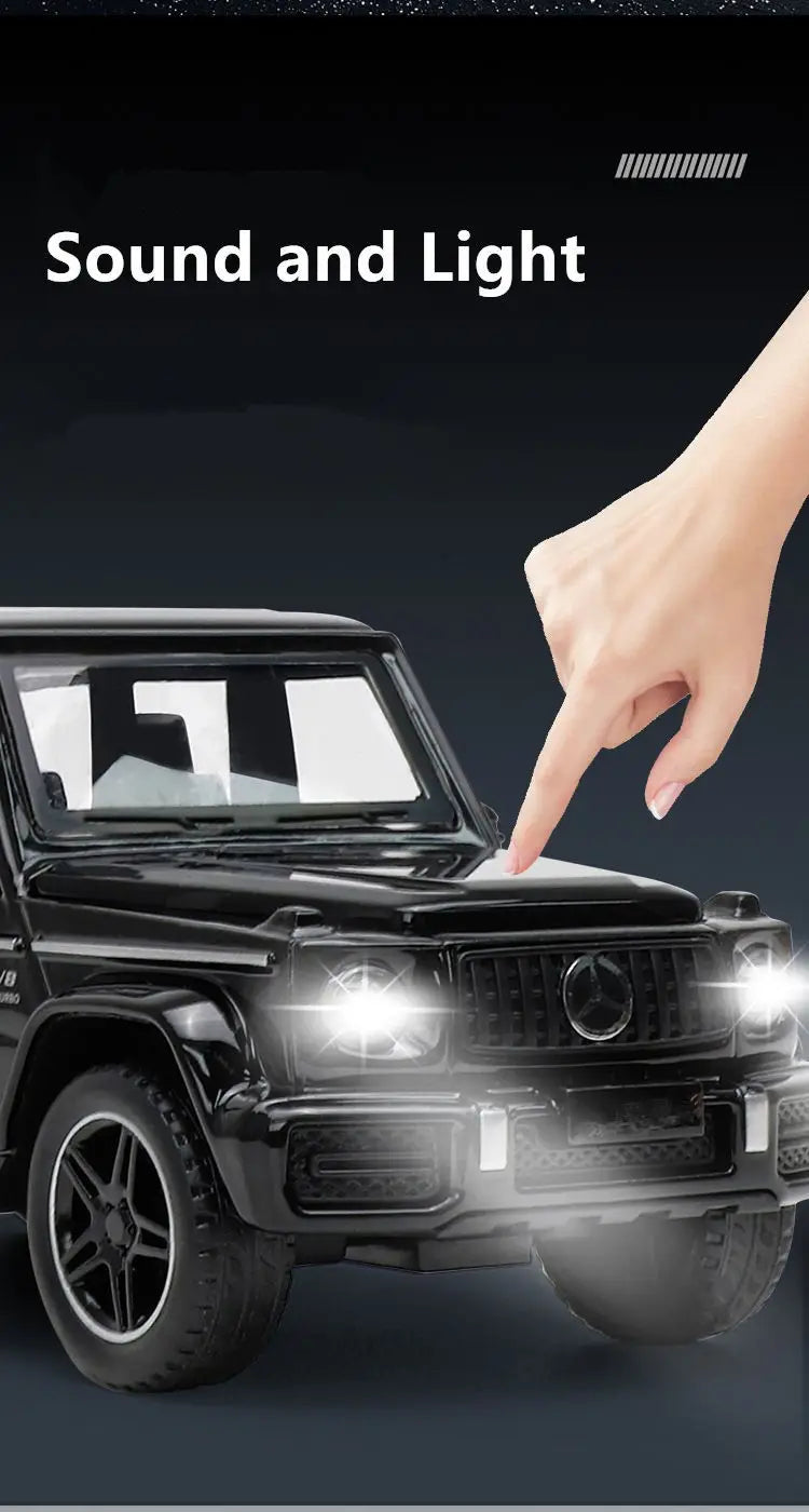 A hand points to the front of a black diecast RV camper truck model with illuminated headlights.