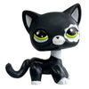 A black and white bobble head figurine of a cat with large green eyes.