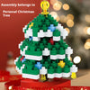 A green Christmas tree built from interlocking plastic bricks with white and blue accents.