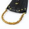 Black faux leather bag with gold studs and bamboo-style handles