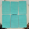 A set of 12 teal tarot cards arranged in a grid on a light-colored surface.