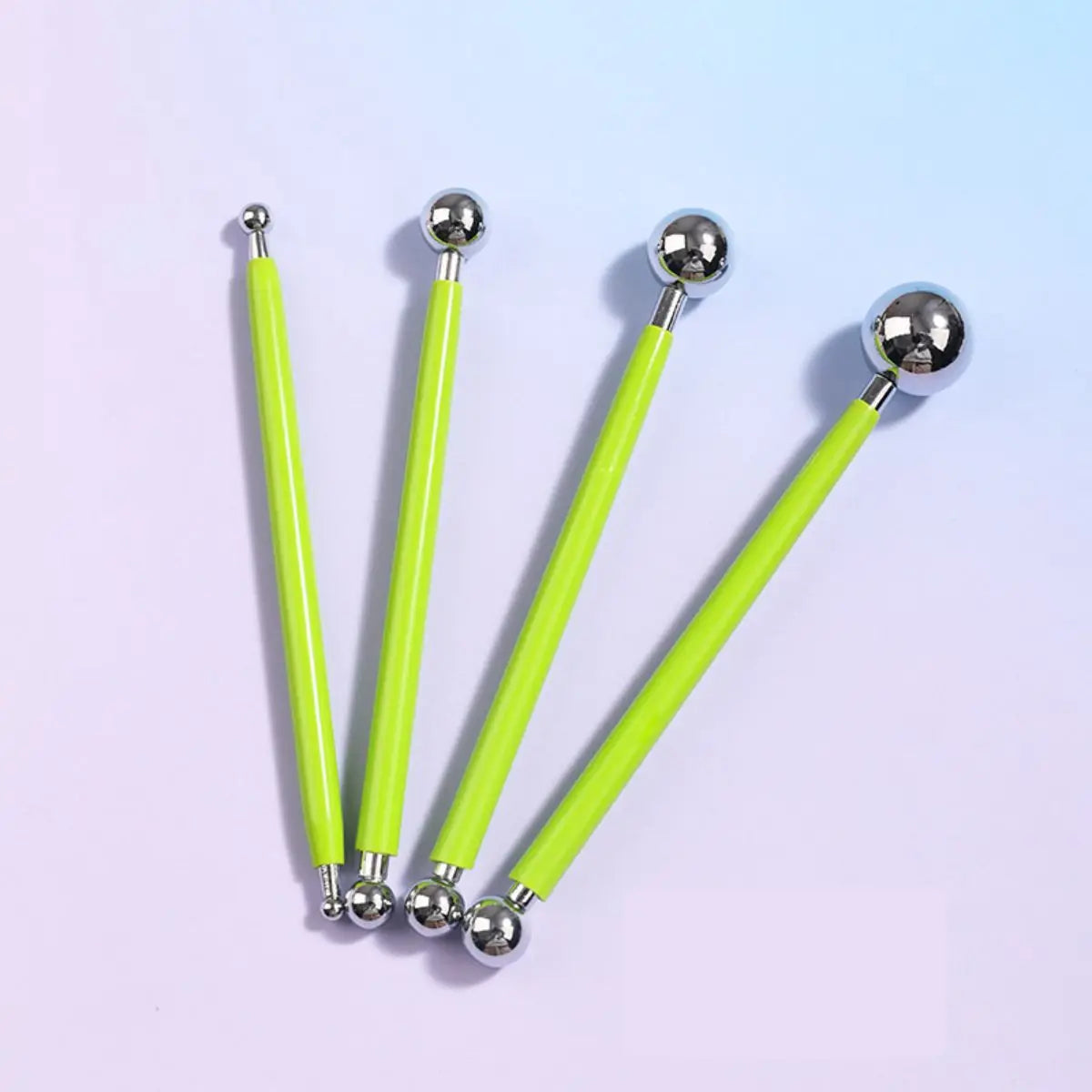 A set of four bright lime green clay sculpting tools with silver tips and handles for pottery and crafting.