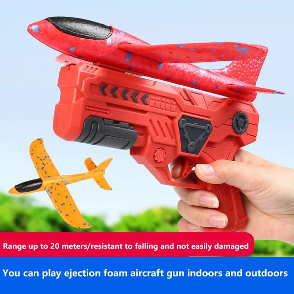 A hand holds a red foam aircraft gun toy designed for indoor and outdoor play.
