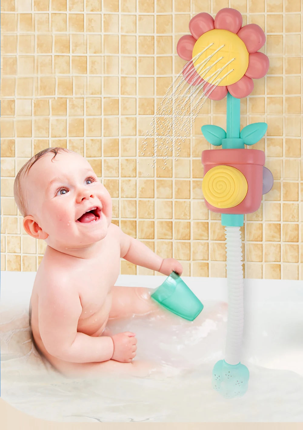 A baby is playing with a pink and yellow sunflower bath shower sprinkler toy in a bathtub.