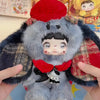 A fluffy gray and red collectible doll resembling a bear or animal, held by a hand.