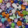 A close-up of colorful butterfly shell acrylic beads in various shades of purple, pink, orange, green, and blue.