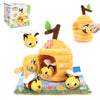 A yellow plush bee toy in a cardboard farm animal house with a green leaf, set for sensory play.